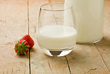 Milk on wooden table with strawberry