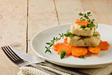 Cod on carrot bed with fresh oregano and basil