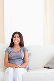 cute smiling woman sitting on a sofa