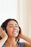 close up of  a smiling woman with closed eyes and earphones