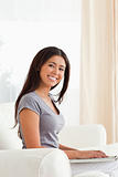 smiling woman sitting on sofa looking into camera