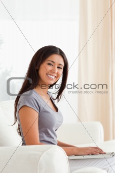 smiling woman sitting on sofa looking into camera