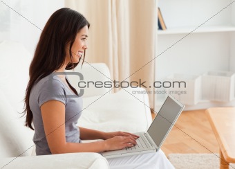 charming woman sitting on sofa with notebook