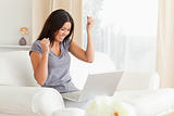 happy woman sitting on sofa with notebook