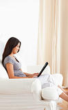 smiling woman sitting on sofa with tablet
