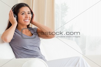 woman sitting on sofa with earphones looking up