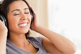 close up of smiling woman sitting on sofa with earphones and eye