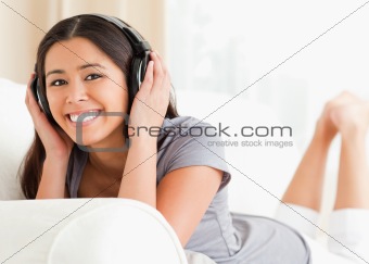 woman lying on sofa with earphones
