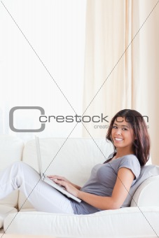cute woman smiling into camera while sitting on dofa