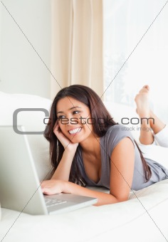 woman lying on sofa looking at notebook