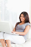 charming woman sitting on sofa with laptop