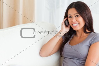 phoning woman on sofa looking into camera