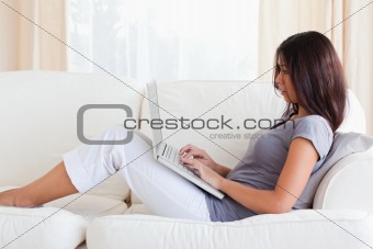 charming woman on sofa with notebook