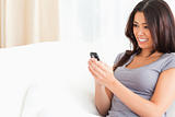 woman sitting on sofa looking at mobile phone