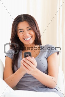 cheerful woman with mobile phone looking into camera