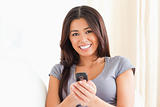 close up of a cheerful woman with mobile phone looking into came
