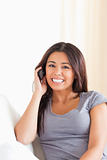 dark-haired woman phoning looking into camera
