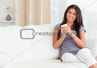 charming woman with cup looking into camera