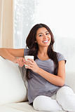 crossleged sitting woman with cup smiling into camera