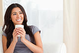 smiling woman holding a cup looking at the ceiling