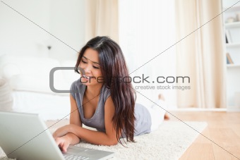 charming woman lying on a carpet with notebook