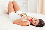 goodlooking woman with rose lying on bed eyes closed
