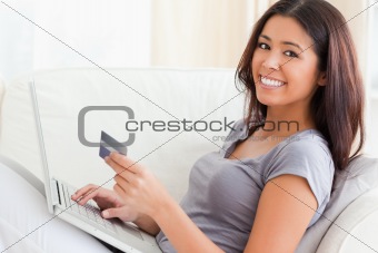 woman on sofa woriking with notebook smiling into camera