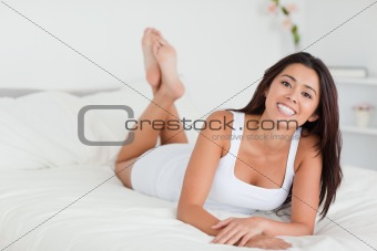 smiling woman lying on bed with crossed legs