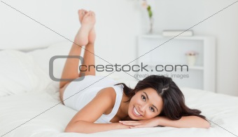 cute woman lying on bed with crossed legs