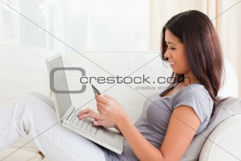 brunette woman working on notebook with card in hands