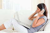 woman sitting on sofa with earphones