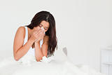 goodlooking woman having a cold sitting in bed