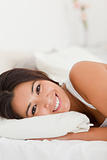 close up of a smiling beautiful woman lying under sheet