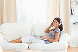 woman sitting on sofa having earphones on