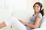 woman with earphones sitting on sofa