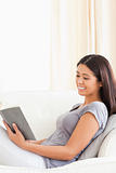 charming woman reading a book sitting on sofa smiling