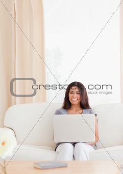 charming woman with notebook sitting on a sofa 