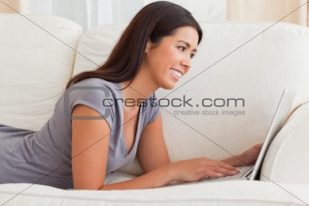 close up of a charming woman lying on sofa with notebook