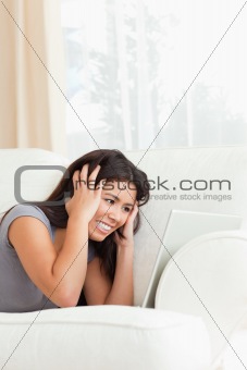 close up of a angry woman lying on sofa with notebook