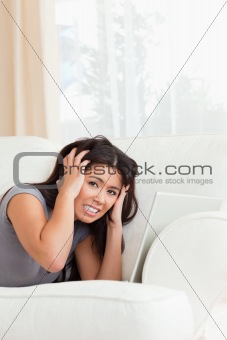 close up of a angry woman lying on sofa with notebook looking in