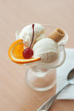 Sweet dessert with ice cream, orange and cherry