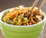 beef lo mein in a bowl with chopsticks