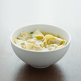 Wonton soup in a white bowl with copyspace