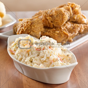 coleslaw with fried chicken in background.