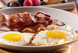 sunny side up eggs with fried bacon.