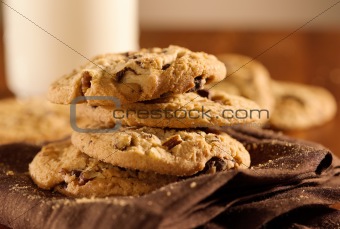 chocolate chip cookies and glass of milk in background