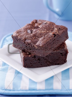 two brownies stacked on a plate.