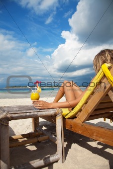 Woman with a cocktail on beach