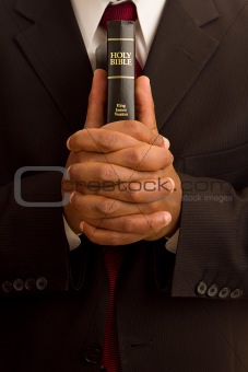 Man Holding Holding Bible While Praying