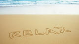 Inscription on beach sand - relax
